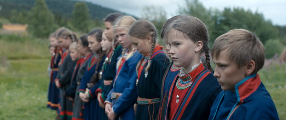 Mehrere Mädchen in traditionellen Gewändern stehen aufgereiht.