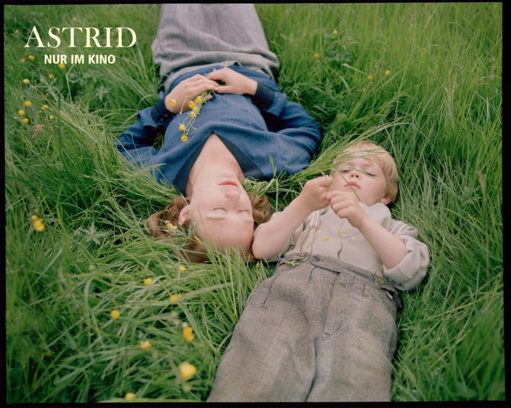 Eine junge Frau und ein blonder Junge liegen im Gras. Oben links in der Ecke steht: "Astrid. Nur im Kino".