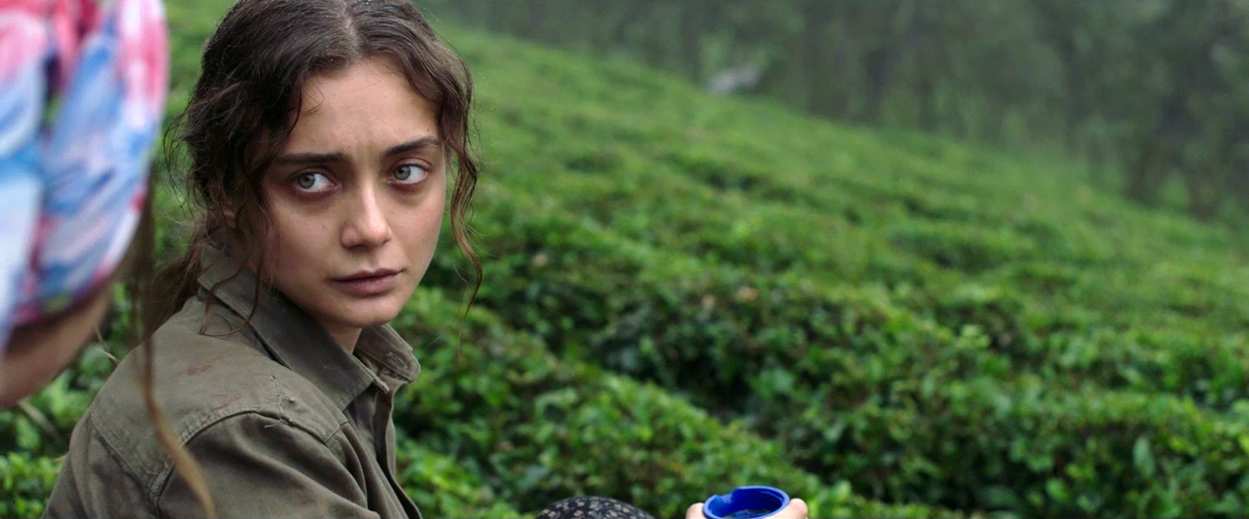 Filmstill aus dem Film "Sibel": An einem grünen Hang eine junge Frau mit einer anderen mit Kopftuch im Gespräch.