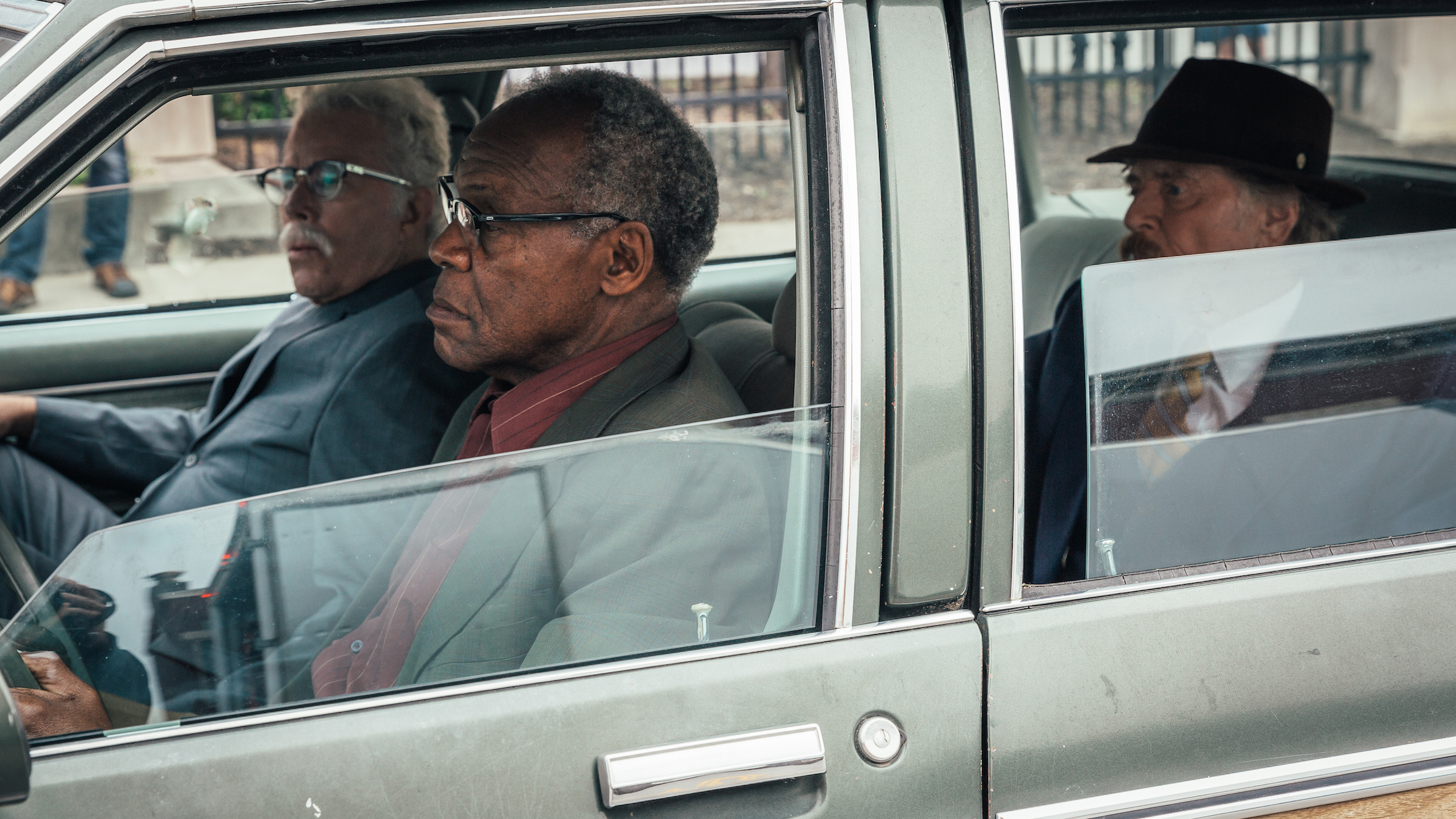 Filmstill aus "Ein Gauner & Gentleman": Drei ältere Herren sitzen in einem Auto.