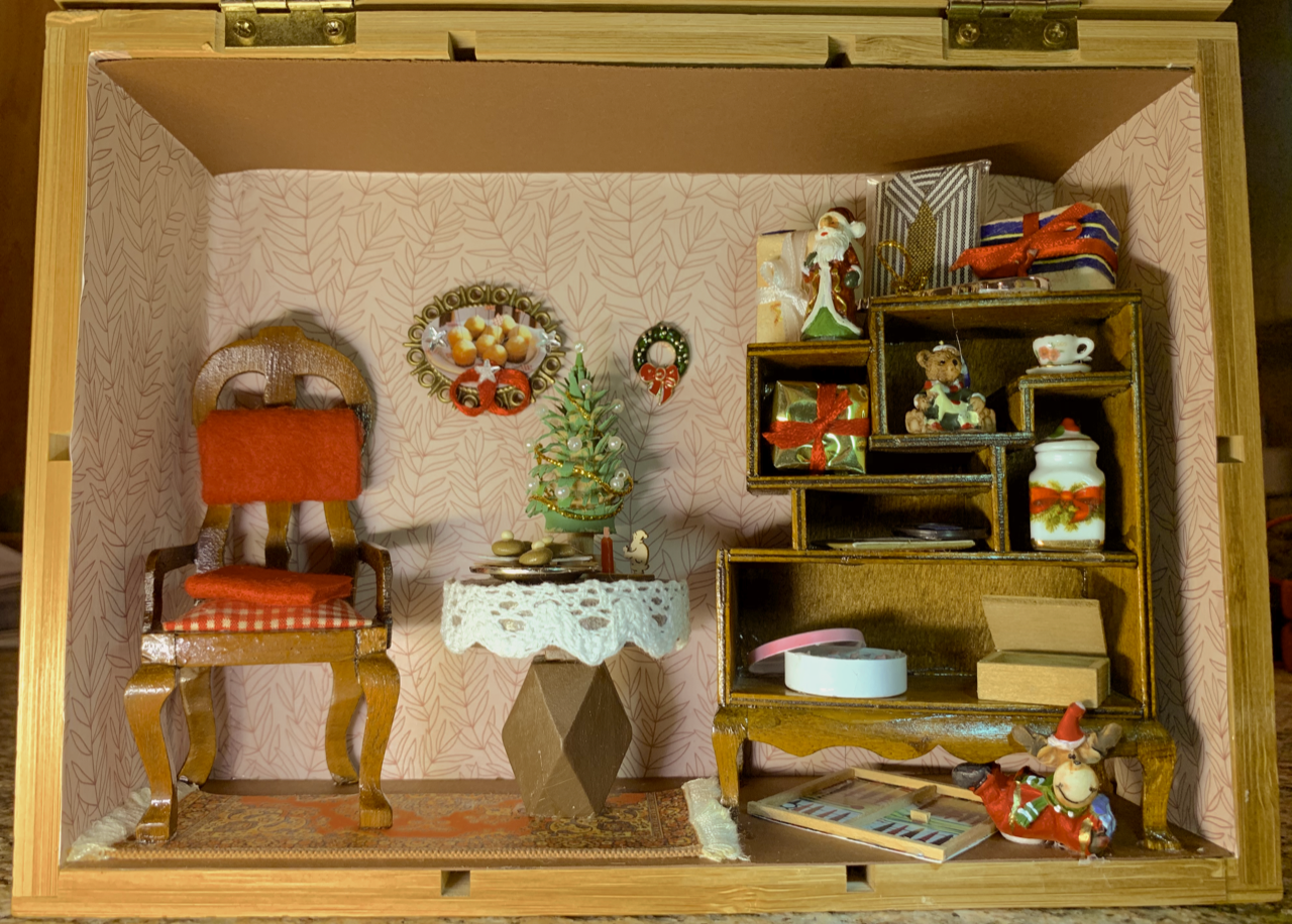 Ein weihnachtlich eingerichtetes Miniaturzimmer in einem Holzkasten